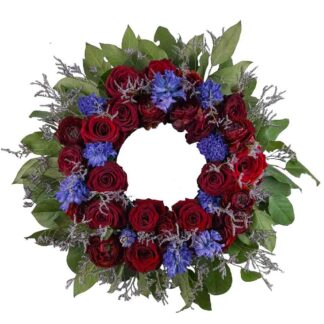 Begravingskrans med röda och blå blommor